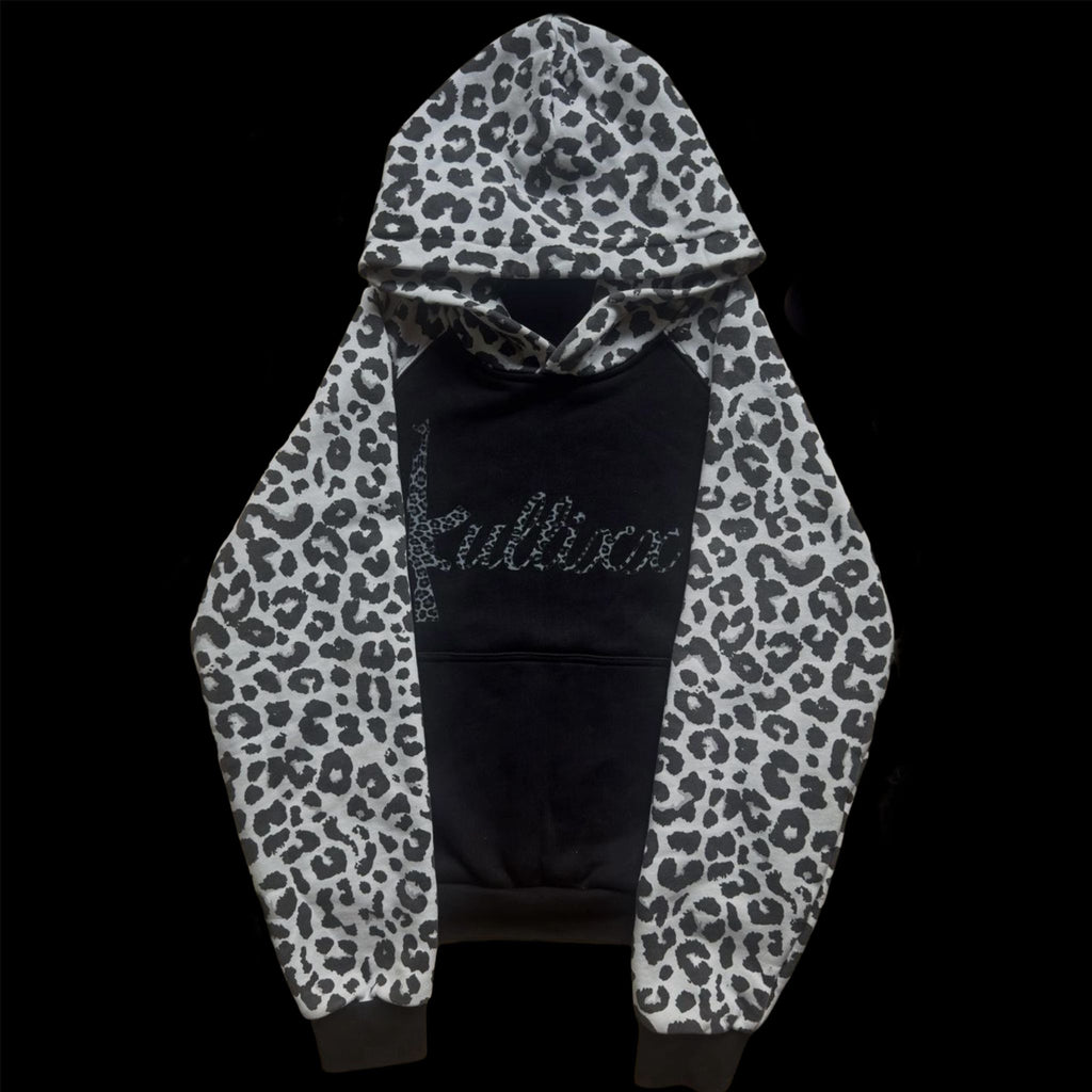 Black hoodie with white leopard print sleeves on a black background